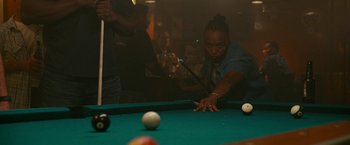 Movie still from “The King of Staten Island” (2020), directed by Judd Apatow – A woman is playing a game of billiards on a pool table; Medium shot, Over the shoulder angle