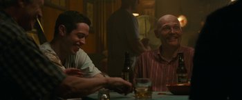 Movie still from “The King of Staten Island” (2020), directed by Judd Apatow – Two men sitting at a table with a bottle of beer; Medium shot, Over the shoulder angle