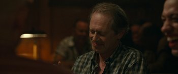 Movie still from “The King of Staten Island” (2020), directed by Judd Apatow – An older man is smiling while looking at something; Close Up shot, Over the shoulder angle