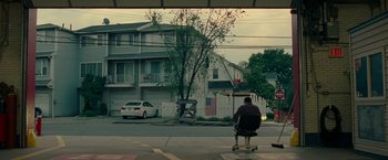 Movie still from “The King of Staten Island” (2020), directed by Judd Apatow – A man sitting on top of a skateboard on the sidewalk; Extreme Wide shot, Low angle