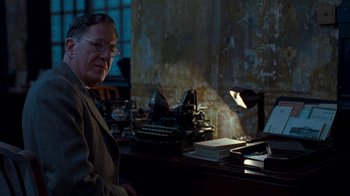 Movie still from “The King's Speech” (2010), directed by Tom Hooper – An older man sitting in front of an old fashioned typewriter; Medium shot, Low angle