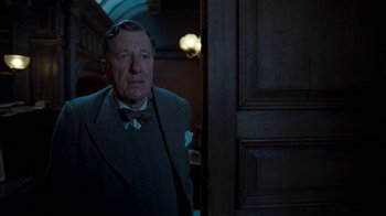 Movie still from “The King's Speech” (2010), directed by Tom Hooper – An older man standing in front of an open door; Medium shot, Low angle