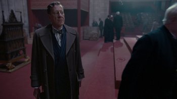 Movie still from “The King's Speech” (2010), directed by Tom Hooper – An older man in a suit and tie standing next to another man in a suit and tie; Medium shot, Over the shoulder angle