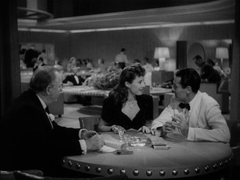 Movie still from “The Lady Eve” (1941), directed by Preston Sturges – A group of people sitting around a table; Medium shot, High angle