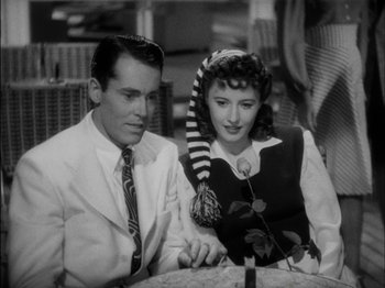 Movie still from “The Lady Eve” (1941), directed by Preston Sturges – A man and a woman sitting at a table; Medium shot, High angle