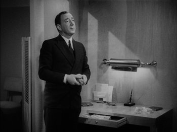 Movie still from “The Lady Eve” (1941), directed by Preston Sturges – A black and white photo of a man in a suit and tie; Medium shot, Low angle