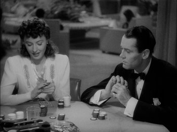 Movie still from “The Lady Eve” (1941), directed by Preston Sturges – A man and a woman sitting at a dinner table; Medium shot, High angle