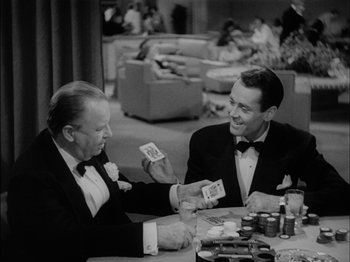 Movie still from “The Lady Eve” (1941), directed by Preston Sturges – Two men in tuxedos playing cards at a table; Medium shot, Over the shoulder angle