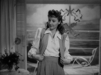 Movie still from “The Lady Eve” (1941), directed by Preston Sturges – A black and white photo of a woman standing in front of a painting; Medium shot, Over the shoulder angle