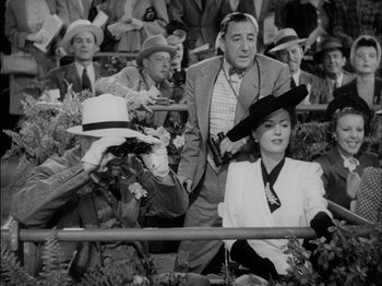 Movie still from “The Lady Eve” (1941), directed by Preston Sturges – A man and a woman are sitting in the stands at a baseball game; Medium shot, High angle