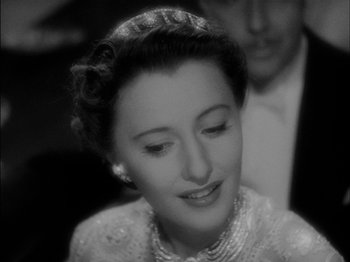 Movie still from “The Lady Eve” (1941), directed by Preston Sturges – A black - and - white photo of a woman in a white dress; Close Up shot, High angle