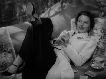 Movie still from “The Lady Eve” (1941), directed by Preston Sturges – An old photo of a woman laying on a couch; Medium shot, Low angle
