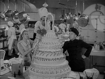 Movie still from “The Lady Eve” (1941), directed by Preston Sturges – An old black and white photo of people in a kitchen; Medium shot, Low angle