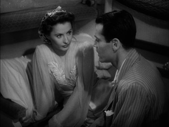 Movie still from “The Lady Eve” (1941), directed by Preston Sturges – A man and a woman sitting on the ground; Medium shot, High angle