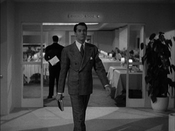 Movie still from “The Lady Eve” (1941), directed by Preston Sturges – A black and white photo of a man in a suit; Medium shot, Over the shoulder angle