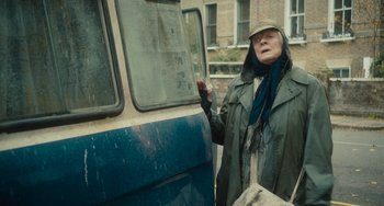 Movie still from “The Lady in the Van” (2015), directed by Nicholas Hytner – An older woman standing next to a bus; Medium shot, Over the shoulder angle