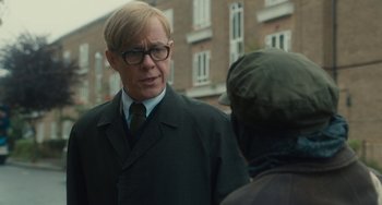 Movie still from “The Lady in the Van” (2015), directed by Nicholas Hytner – A man wearing a suit and tie talking to a person; Close Up shot, Over the shoulder angle