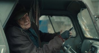 Movie still from “The Lady in the Van” (2015), directed by Nicholas Hytner – An old woman driving a car holding a cell phone; Close Up shot, High angle