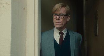 Movie still from “The Lady in the Van” (2015), directed by Nicholas Hytner – A man in a suit and tie standing in front of a door; Close Up shot, Low angle