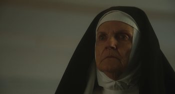 Movie still from “The Lady in the Van” (2015), directed by Nicholas Hytner – An older woman wearing a nun's habit and looking at the camera; Close Up shot, Low angle