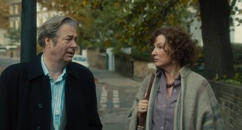 Movie still from “The Lady in the Van” (2015), directed by Nicholas Hytner – A man and a woman standing next to each other on a sidewalk; Close Up shot, Over the shoulder angle