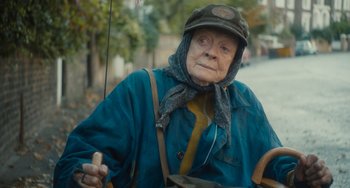 Movie still from “The Lady in the Van” (2015), directed by Nicholas Hytner – An old woman wearing a hat and a blue jacket; Close Up shot, Over the shoulder angle