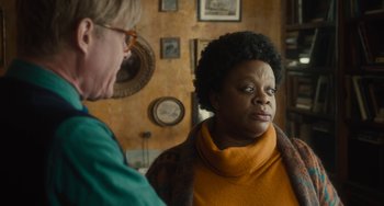 Movie still from “The Lady in the Van” (2015), directed by Nicholas Hytner – Two people are talking in a room with a wall of pictures; Close Up shot, Over the shoulder angle