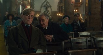 Movie still from “The Lady in the Van” (2015), directed by Nicholas Hytner – A group of people sitting in a room; Medium shot, Over the shoulder angle