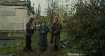 Movie still from “The Lady in the Van” (2015), directed by Nicholas Hytner – A group of people standing in a cemetery; Wide shot, Over the shoulder angle