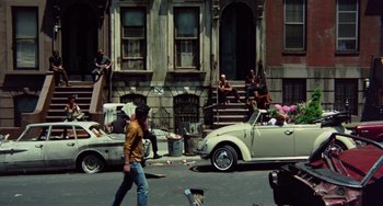 Movie still from “The Landlord” (1970), directed by Hal Ashby – A group of people sitting on the side of a road; Wide shot, High angle