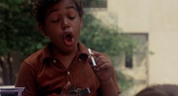 Movie still from “The Landlord” (1970), directed by Hal Ashby – A young boy holding a cell phone in his hand; Close Up shot, High angle
