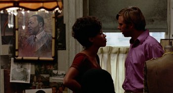 Movie still from “The Landlord” (1970), directed by Hal Ashby – A man and a woman standing next to each other in a room; Medium shot, Over the shoulder angle