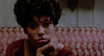 Movie still from “The Landlord” (1970), directed by Hal Ashby – A person sitting on a couch with her hand on her chin; Close Up shot, Low angle