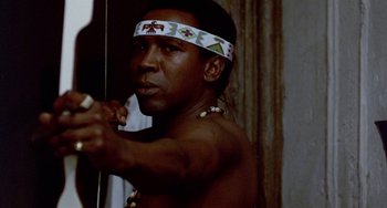 Movie still from “The Landlord” (1970), directed by Hal Ashby – A man is holding a bow and arrow in his hands; Close Up shot, Low angle