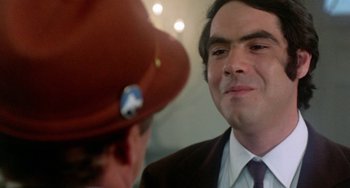 Movie still from “The Landlord” (1970), directed by Hal Ashby – A man wearing a red hat and a brown tie; Close Up shot, Over the shoulder angle