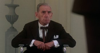 Movie still from “The Landlord” (1970), directed by Hal Ashby – An older man in a suit and bow tie sitting in a chair; Close Up shot, Over the shoulder angle