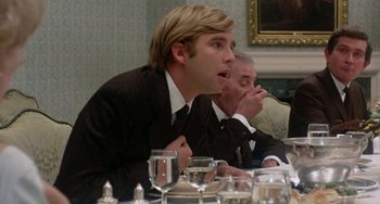 Movie still from “The Landlord” (1970), directed by Hal Ashby – A man in a suit and tie sitting in front of a table; Close Up shot, Over the shoulder angle