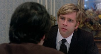 Movie still from “The Landlord” (1970), directed by Hal Ashby – A man in a business suit talking to another man in a business suit; Close Up shot, Over the shoulder angle