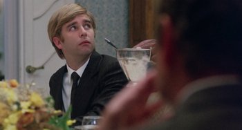 Movie still from “The Landlord” (1970), directed by Hal Ashby – A man in a suit and tie sitting at a dinner table; Close Up shot, Over the shoulder angle