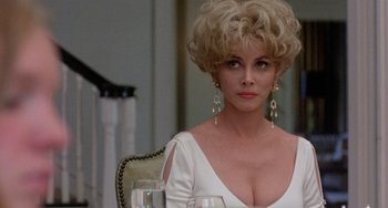 Movie still from “The Landlord” (1970), directed by Hal Ashby – A woman in a white dress sitting at a table; Close Up shot, Over the shoulder angle