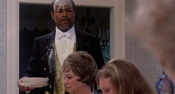 Movie still from “The Landlord” (1970), directed by Hal Ashby – A man standing in front of a group of people; Medium shot, Over the shoulder angle