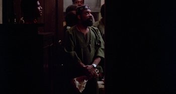 Movie still from “The Landlord” (1970), directed by Hal Ashby – A man in a green shirt holding something in his hand; Medium shot, Low angle