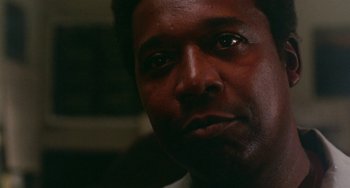 Movie still from “The Landlord” (1970), directed by Hal Ashby – A man's face in a dark room; Close Up shot, Low angle