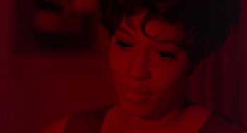 Movie still from “The Landlord” (1970), directed by Hal Ashby – A woman's face in red light; Close Up shot, High angle