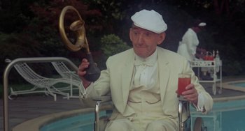 Movie still from “The Landlord” (1970), directed by Hal Ashby – An older man in a white suit holding a steering wheel; Medium shot, Low angle