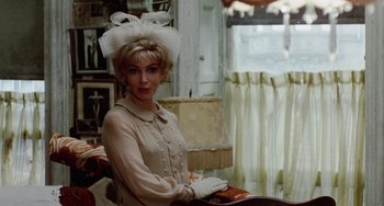 Movie still from “The Landlord” (1970), directed by Hal Ashby – A woman wearing a white hat and a beige dress; Medium shot, Over the shoulder angle