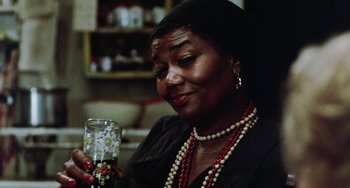 Movie still from “The Landlord” (1970), directed by Hal Ashby – A woman sitting at a table with a glass of wine; Close Up shot, Over the shoulder angle