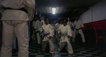 Movie still from “The Landlord” (1970), directed by Hal Ashby – A group of young men in white uniforms practicing martial arts; Wide shot, Low angle