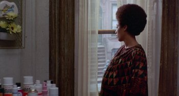 Movie still from “The Landlord” (1970), directed by Hal Ashby – A woman standing in front of a window with her eyes closed; Medium shot, Over the shoulder angle