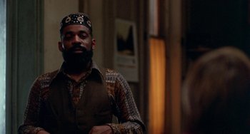 Movie still from “The Landlord” (1970), directed by Hal Ashby – A man with a beard wearing a hat and a vest; Medium shot, Low angle